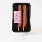 Zwei vegane Fleischspieße auf Holzstäbchen in schwarzer Verpackung – Lotti Vleischspießal von Die Pflanzerei, pflanzlicher Fleischersatz