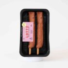 Zwei vegane Fleischspieße auf Holzstäbchen in schwarzer Verpackung – Lotti Vleischspießal von Die Pflanzerei, pflanzlicher Fleischersatz fürs BBQ.